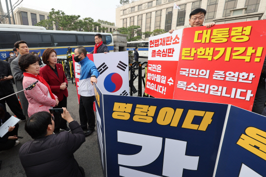 25일 서울 종로구 헌법재판소 앞에서 윤석열 대통령 탄핵 반대 피케팅 하던 나경원 국미의힘 의원과 윤 대통령 파면 촉구 피케팅을 준비하던 박홍배 더불어민주당 의원이 대화하고 있다. [연합뉴스]